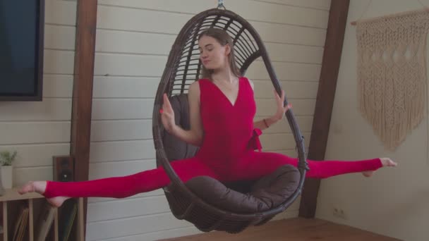 Cute sporty fit woman doing splits in swing chair — Stock Footage Cute sporty fit woman doing splits in swing chair Royalty Free Stock Footage