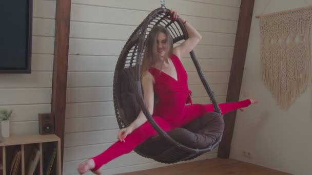 Femme flexible assise sur ficelle dans une chaise suspendue — Video