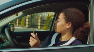 Gururlu kadın yeni araba sahibi sürücü koltuğunda oturuyor.