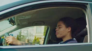 Şoför koltuğunda gülümseyen pozitif siyah kadın.