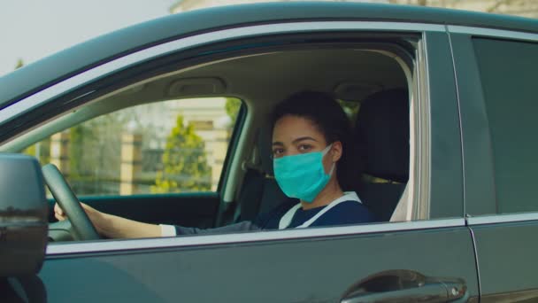 Nero donna autista in auto indossando maschera medica — Video Stock