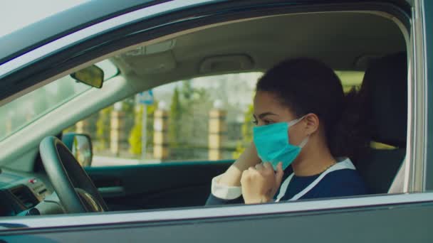Kvinna i bil ta på mask och handskar under epidemi — Stockvideo