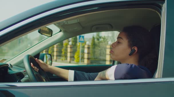 차에 무선 전화 헤드셋을 장착 한 여성 운전자 — 비디오