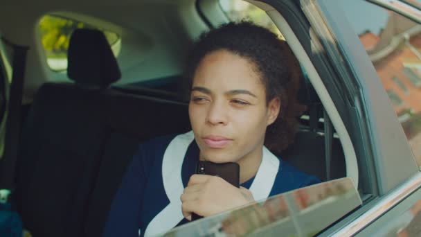 Mujer de negocios pensativa con teléfono sentado en el asiento trasero del coche — Vídeos de Stock
