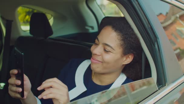 車の後部座席で電話で素敵な女性のネットワーキング — ストック動画