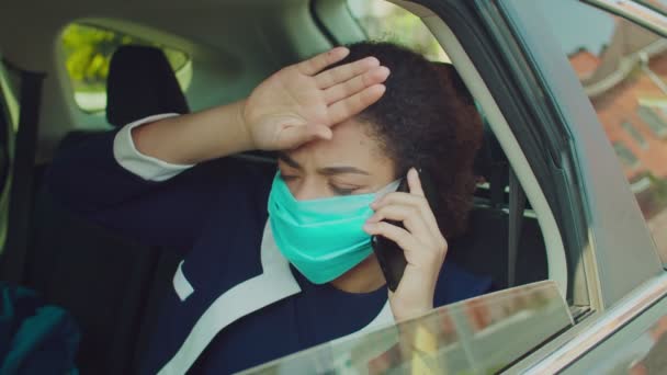 Γυναίκα με προστατευτική μάσκα μιλώντας στο τηλέφωνο στο αυτοκίνητο — Αρχείο Βίντεο