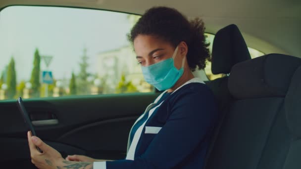 Femme d'affaires enlève masque médical dans le siège arrière de la voiture — Video