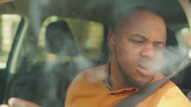 Nervous african male driver smoking cigarette in car — Stock Video