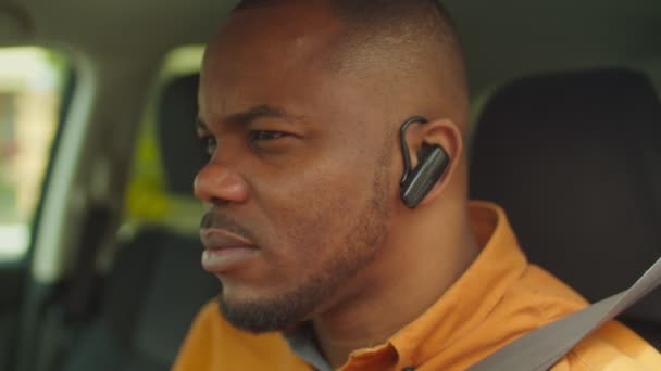 Black man in car talking using hands-free device — Stock Video