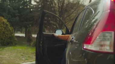 Park halindeki arabadan inen kendine güvenen siyahi adam.