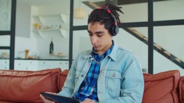 Ciddi bir Arap erkek öğrenci evde internetten öğreniyor.