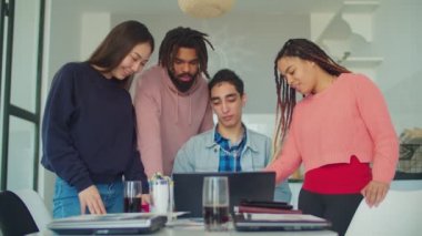 Yaratıcı ekip merkez ofiste dizüstü bilgisayarın etrafında toplandı