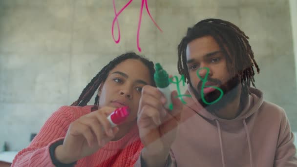 Diverse studenten tekenen met stiften op glasplaat — Stockvideo