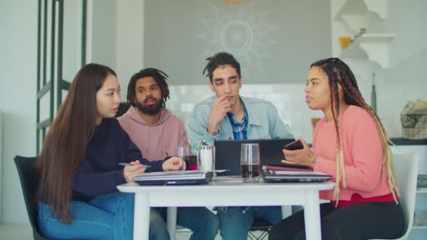 Amis multiraciaux se détendre dans la cuisine après avoir étudié — Video