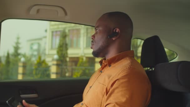 車の後部座席で手のないデバイスを使用してビジネスマン — ストック動画