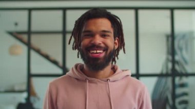 Neşeli Afro-Amerikan hipster içeride gülümsüyor.