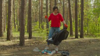 Asyalı gönüllü kadın orman çöplerini temizliyor