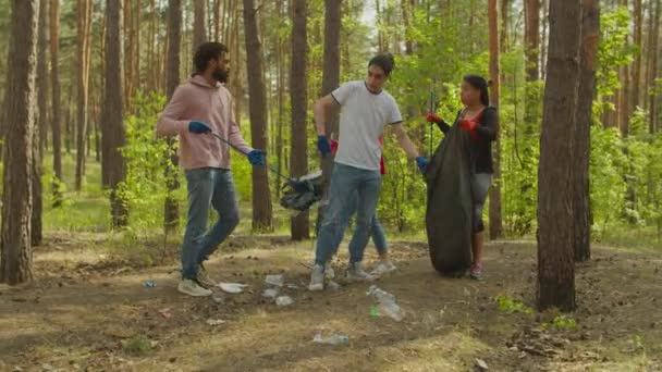 Pečující lidé sbírat plastové odpadky ve dřevě — Stock video