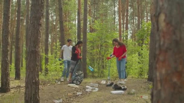 Wieloetniczni wolontariusze sprzątający śmieci w lesie — Wideo stockowe