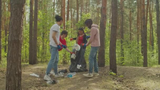 Mulitiraciale mensen ruimen bos op uit plastic afval — Stockvideo