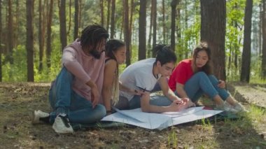 Çeşitli insanlar ormanda ekoloji pankartları yaratıyor.