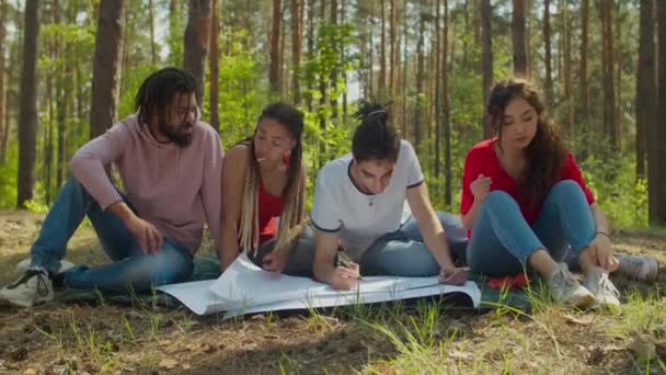 Voluntarios ecológicos creativos haciendo pancartas en el bosque — Vídeo de stock