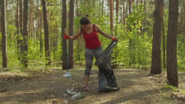 Tired female activist collecting garbage outdoors — Stock Video