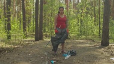 Ormanda çöp toplayan siyah kadın gönüllü.