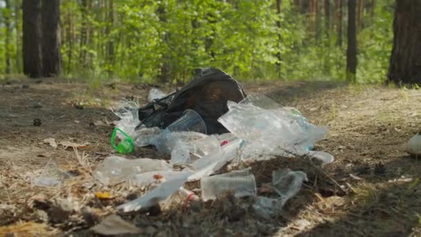 Gleichgültiger Mann tritt über Müllhaufen im Wald — Stockvideo