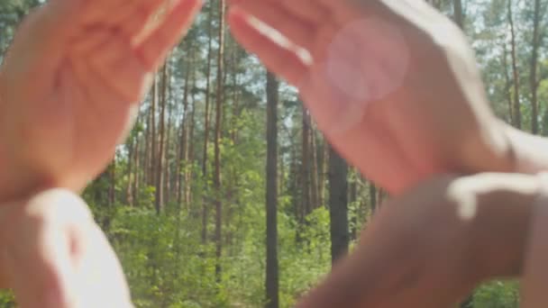 Pareja mostrando la forma de la tierra con las manos al aire libre — Vídeos de Stock