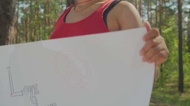 Ekologi protesterande kvinna med plakat i skogen — Stockvideo