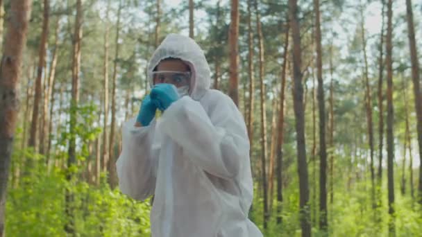 Mann im Biohazard-Anzug wirft Schläge in die Natur — Stockvideo