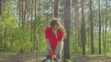 Asyalı kadın çevreci, çöp torbası taşıyor.