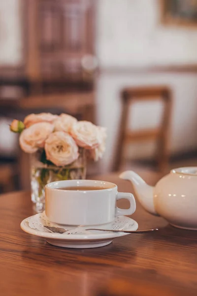 Güzel taze güller bir fincan çayın yanında ve pastel tonlarda romantik bir ruh hali..