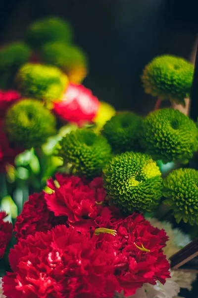 Still life with red green bouquet on the dark background