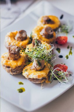 Peynir, mantar sapı, taze vişneli domates ve mikroyeşil mantarla doldurulmuş mantarlar..