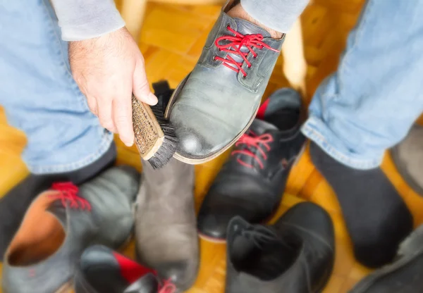 Een man reinigt de schoenen met een borstel, bootblack — Stockfoto