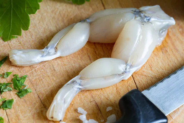 Gambe di rana crude sul tagliere in cucina primo piano — Foto Stock