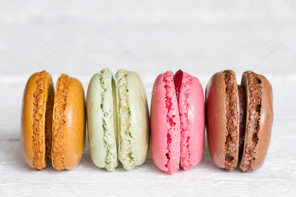 Colorful macarons, macaroons cake on white wooden background closeup