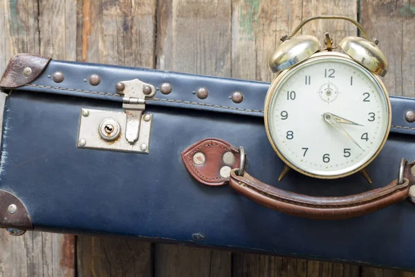 Sista minuten resor koncept med gamla retro resväska och väckarklocka — Stockfoto