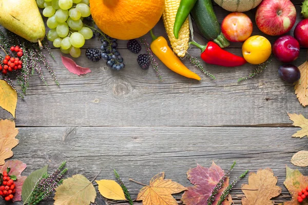 Frutta e verdura autunnali su uno sfondo di legno retrò con foglie — Foto Stock