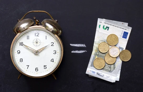 Zeit ist Geld mit Wecker und Euro an der Tafel — Stockfoto