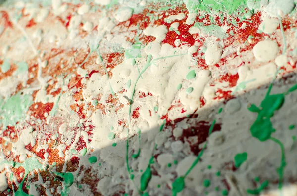 spots and splashes of white, red and green paint on background. abstract pattern for decoration.