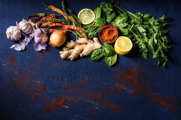 Top view of parsley, basil, lemon, peppers, onion, garlic and ginger on blue — Stock Photo