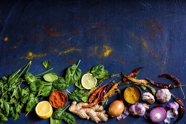 Vue de dessus de savoureuses herbes saines, légumes et épices sur bleu — Photo de stock