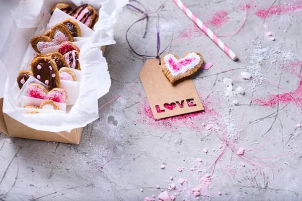 Close-up vista da caixa com doces namorados biscoitos com etiqueta de amor na superfície cinza — Fotografia de Stock