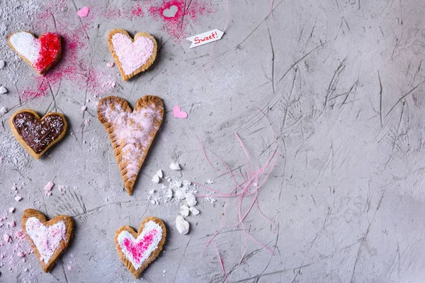 Draufsicht auf süße herzförmige Plätzchen zum Valentinstag auf grauer rissiger Oberfläche — Stockfoto