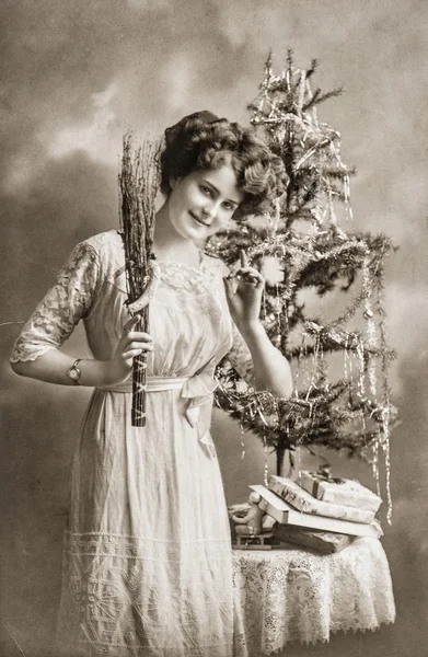 Young woman with christmas tree and gifts. Antique picture Royalty Free Stock Photos