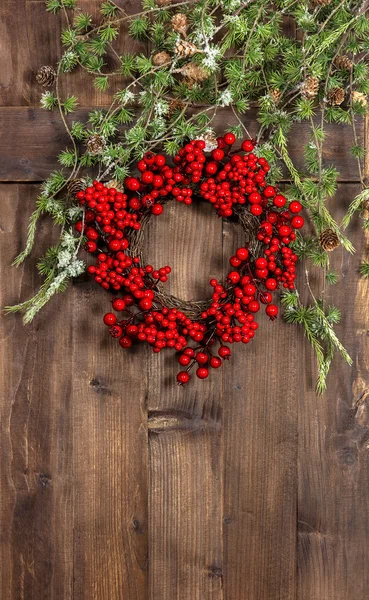ChrisChristmas tree branches and wreath from red berries — Stock Photo, Image