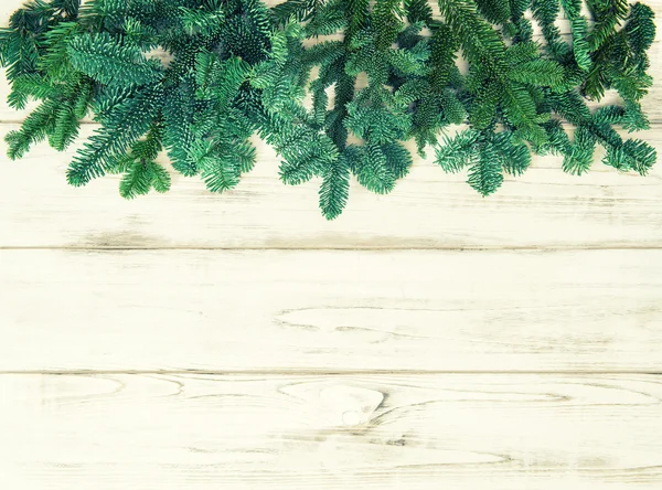 Weihnachtsbaum Äste über Holz Hintergrund. — Stockfoto